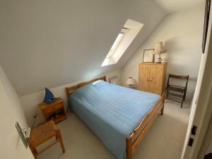 a bedroom with a bed and a chair in it at Maison Normandie 19 in Fort-Mahon-Plage