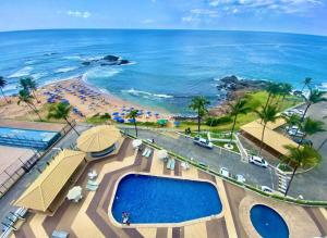 an aerial view of a resort with a pool and the beach at Ondina Apart Hotel 02 quartos Vista Mar in Salvador