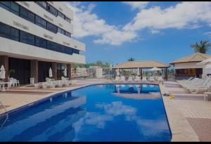 a large swimming pool in front of a building at Ondina Apart Hotel 02 quartos Vista Mar in Salvador