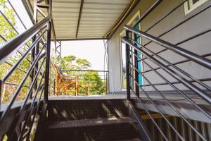 Una escalera que conduce a un balcón con una silla. en Casa Container, 15 min da Praia no Campeche SUL91, en Florianópolis