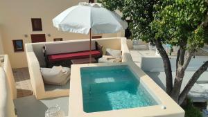 a swimming pool sitting on a table with an umbrella at Dreamer's secret villa II in Emporio Santorini