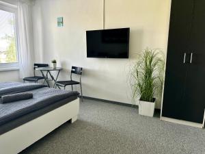 a bedroom with a bed and a tv on a wall at City Apartment in Štúrovo