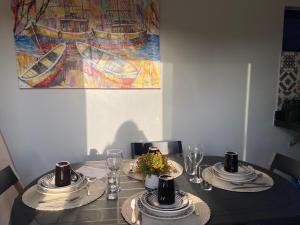 a dining room table with plates and glasses and a painting at Ville Acqua Park in Bragança