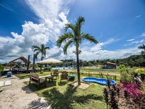 a palm tree sitting next to a table and chairs at Ville Acqua Park in Bragança