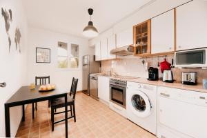 - une cuisine avec une table et un lave-linge/sèche-linge dans l'établissement SPÉCIAL COUPLE & FAMILLE - Lit Queen Size - NETFLIX - Climatisation - Terrasse Plein Sud - 2 min Centre-Ville - 6 min Mer - Wifi 400 Mbits Parking privé - OFFRE SPÉCIALE, à La Londe-les-Maures