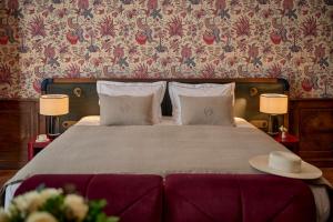 a bedroom with a bed with two tables and two lamps at Faubourg 21 in Brussels