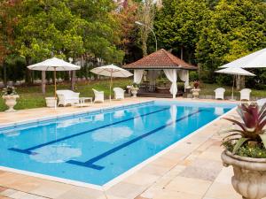 a large swimming pool with chairs and umbrellas at Kurotel Centro Contemporâneo de Saúde e Bem Estar in Gramado