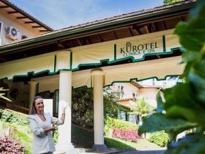 a woman standing in front of a building at Kurotel Centro Contemporâneo de Saúde e Bem Estar in Gramado