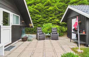 two chairs sitting on a patio next to a garage at Nice Home In Ebeltoft With Wifi in Ebeltoft +14 photos