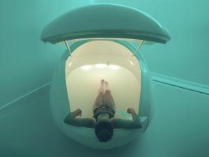 a woman laying in a glass bubble in a swimming pool at Kurotel Centro Contemporâneo de Saúde e Bem Estar in Gramado