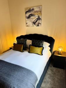 a bedroom with a bed with yellow and black pillows at Kexby House in York