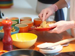 a person preparing food in a bowl on a table at Kurotel Centro Contemporâneo de Saúde e Bem Estar in Gramado