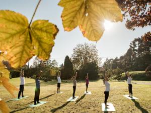a group of people doing yoga in a park at Kurotel Centro Contemporâneo de Saúde e Bem Estar in Gramado