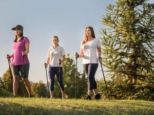 three women are standing on the grass with poles at Kurotel Centro Contemporâneo de Saúde e Bem Estar in Gramado