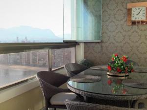 una mesa con sillas y un reloj en una habitación en Benidorm Gemelos penthouse with private pool, en Benidorm