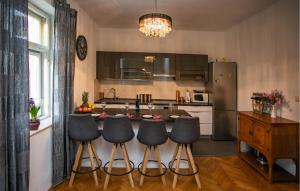 a kitchen with a bar with four stools in it at Awesome Home In Split in Split