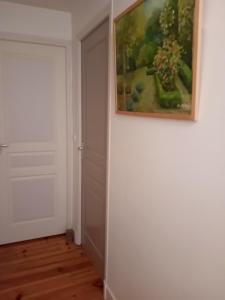 ein Gemälde, das an einer Wand neben einer Tür hängt in der Unterkunft CHEZ ISA chambre chez l'habitant Antoine in Montlouis-sur-Loire