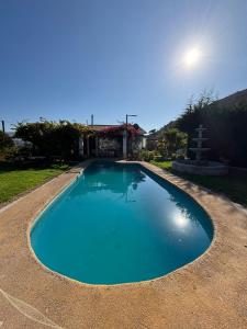 a blue swimming pool in front of a house at Cabañas Punta de Piedra in Punta de Piedra +1 photo