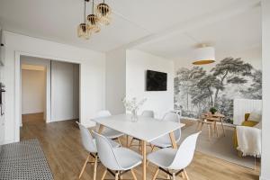ein weißes Esszimmer mit einem weißen Tisch und Stühlen in der Unterkunft Magnifique Chambre dans une collocation design in Rouen