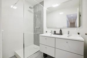 ein weißes Badezimmer mit Waschbecken und Dusche in der Unterkunft Magnifique Chambre dans une collocation design in Rouen
