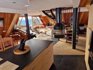 a kitchen and living room with a large stove at le chalet pointu de capucine in Bourg-Saint-Maurice