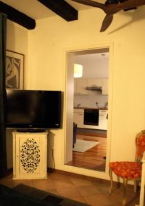 a living room with a television and a mirror at Il Florino in Merano +24 photos