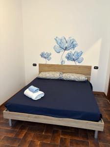 a bed with a blue bedspread and towels on it at Miro' dreams in Alzate Brianza