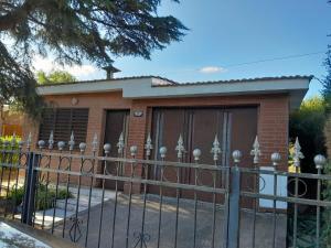a house with a fence in front of it at La Morada de sus Sueños in Bialet Massé