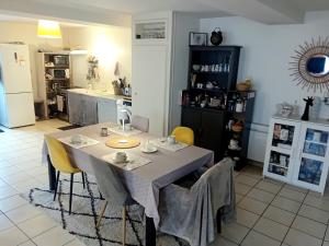 eine Küche mit einem Tisch und Stühlen in einer Küche in der Unterkunft CHEZ ISA chambre chez l'habitant Antoine in Montlouis-sur-Loire