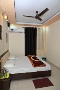 a bedroom with a bed with a ceiling fan at Thapliyal Homestay in Rishīkesh +5 photos
