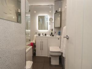 a white bathroom with a toilet and a sink at 17 Alexandra Court in Skipton