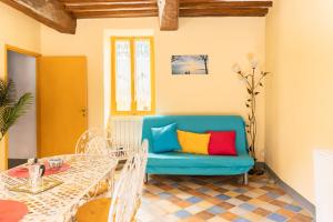 ein Wohnzimmer mit einem blauen Sofa und einem Tisch in der Unterkunft Lago Trasimeno - La Casa del Pescatore - vicino a Perugia in San Feliciano