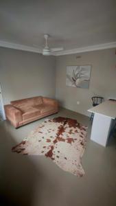 a living room with a couch and a rug at Casuarina Cabin in Clansthal +23 photos