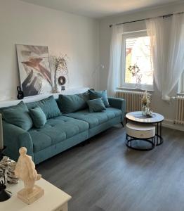 a living room with a blue couch and a table at Quartier Lookvenne Wohnung 4 in Emden
