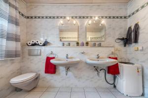 a bathroom with two sinks and a toilet and mirrors at Ferienhaus Am Waldrand in Wietze +14 photos