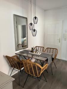 a dining room with a table and chairs and a mirror at Quartier Lookvenne Wohnung 4 in Emden