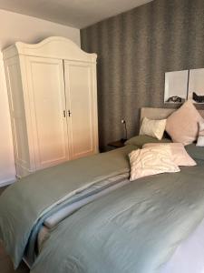 a bedroom with a bed with a white cabinet at Quartier Lookvenne Wohnung 4 in Emden