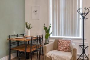 a dining room with a table and a chair at Comfortable 3 Bedroom Home with Parking Pet Friendly Sleeps 8 in Knowsthorpe
