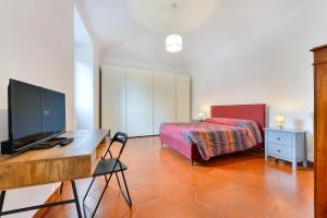Un dormitorio con una cama y un escritorio con televisión. en Lavinia's Apartment at Colosseo, en Roma