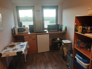 a small room with a desk and two windows at Gästezimmer von Annegret in Peine