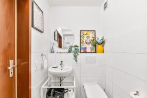 Un baño blanco con lavabo e inodoro. en Black Forest Flower Apartment, en Bad Wildbad 49 fotos más