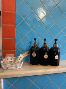 two black bottles on a shelf in a bathroom at Il Gallo di Gallura in Tempio Pausania