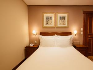 a bedroom with a large white bed with two night stands at Kurotel Centro Contemporâneo de Saúde e Bem Estar in Gramado +26 photos
