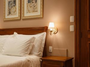 a bedroom with a bed with a lamp on a table at Kurotel Centro Contemporâneo de Saúde e Bem Estar in Gramado