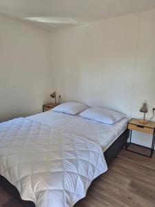 a bedroom with a large bed with white sheets at Eldorado in Petten
