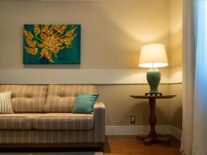 a living room with a couch and a lamp at Kurotel Centro Contemporâneo de Saúde e Bem Estar in Gramado