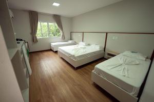a hotel room with two beds and a window at Ody Park Resort Hotel in Iguaraçu
