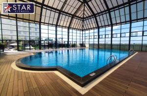 a large swimming pool in a building with windows at Happiest Homestay 2 - Manor Crown Hue in Thôn Trường Giang