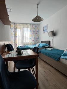 a bedroom with two beds and a table and chairs at Marino in Kołobrzeg