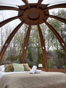a bed in a room with a large window at Wigwam et Dôdome sous les étoiles in Champfromier +22 photos